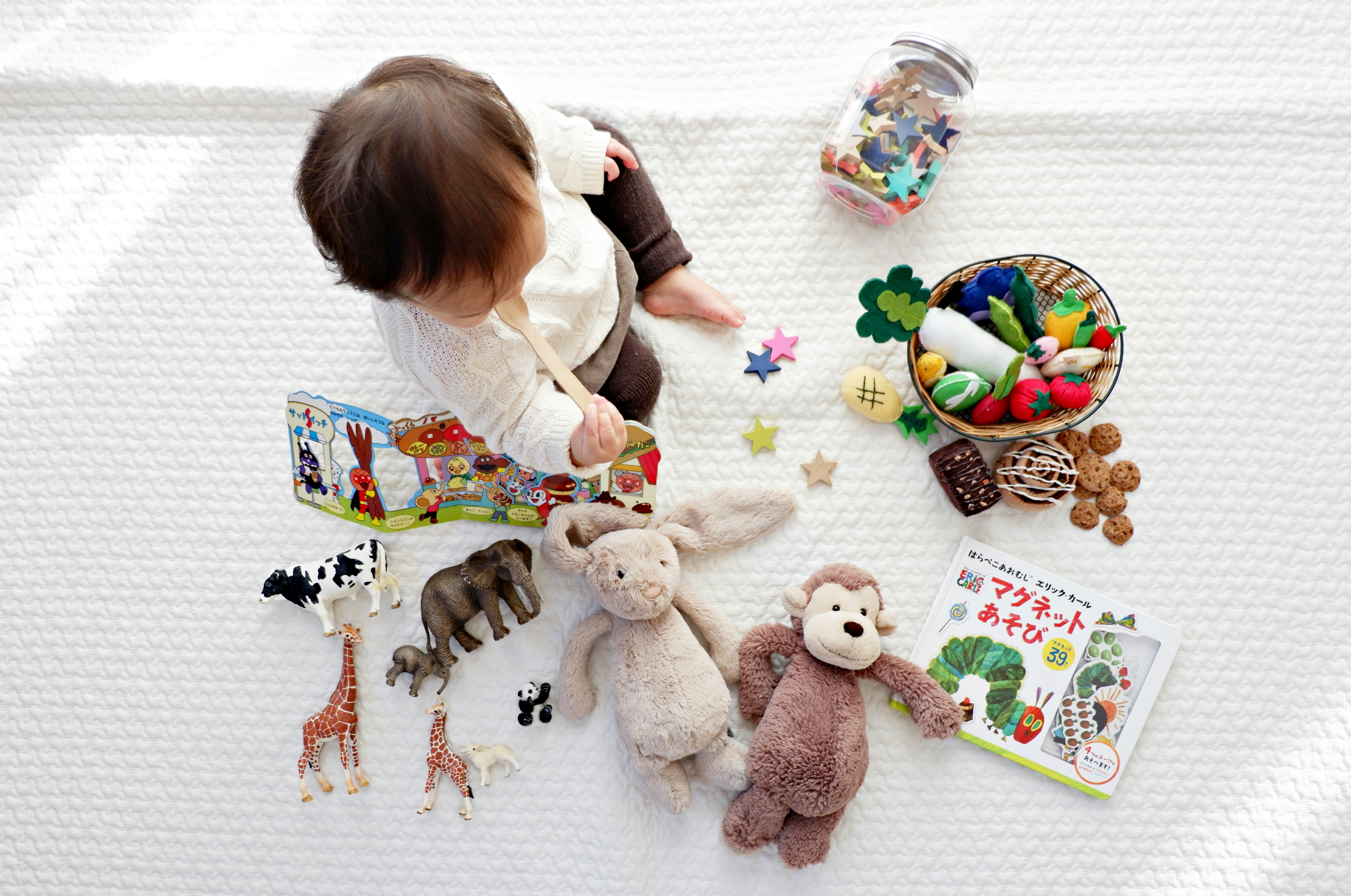 Child playing with educational toys, books and stuffed animals